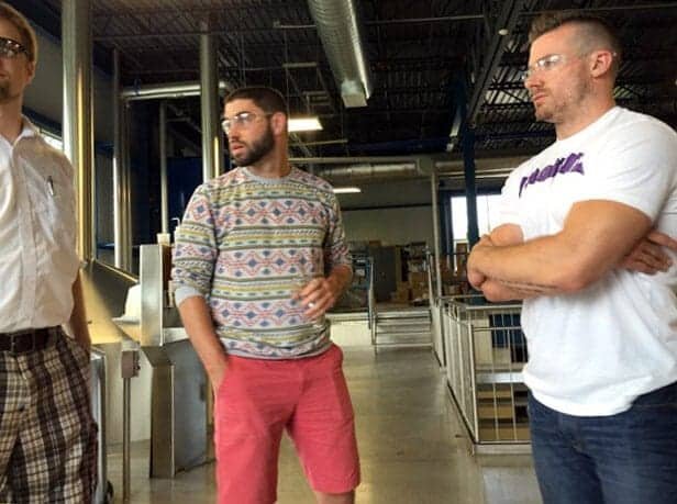 Serveral men standing in a brewery