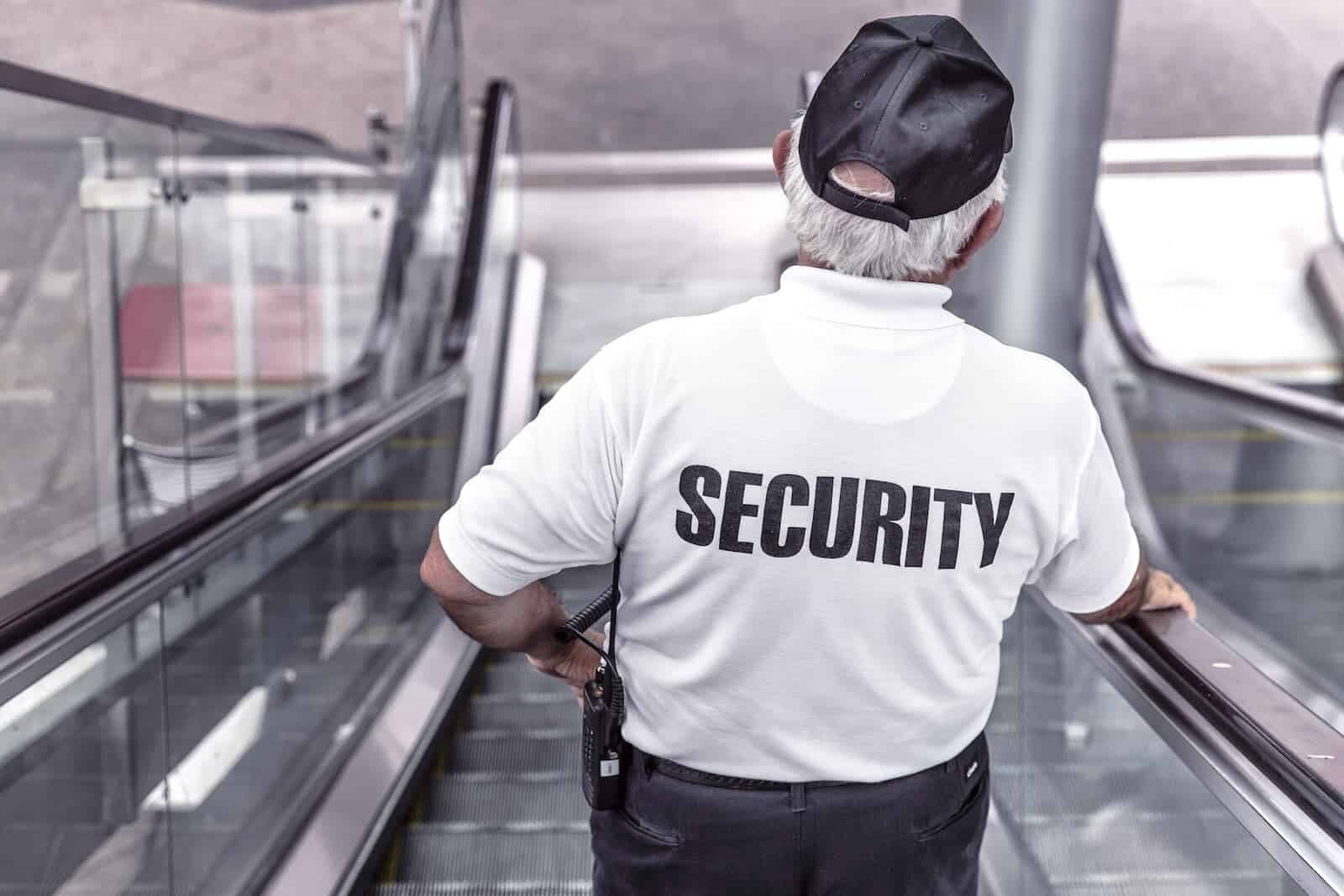A man wearing a white shirt that says "Security" on the back