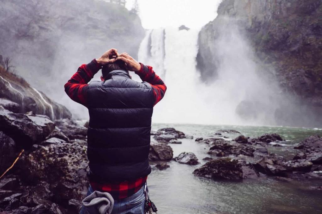 Dramatic man holding head at waterfall